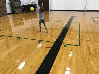 Elementary practicing volleyball serve